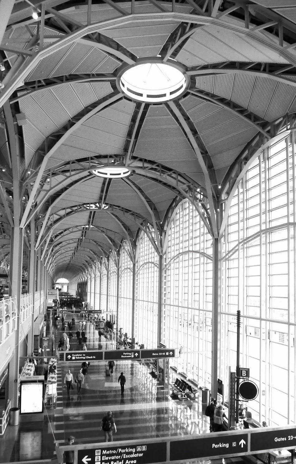 Black and white view down the arched steel-and-glass terminal hall of Reagan National Airport