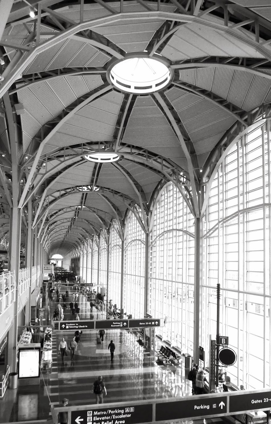Black and white view down the arched steel-and-glass terminal hall of Reagan National Airport